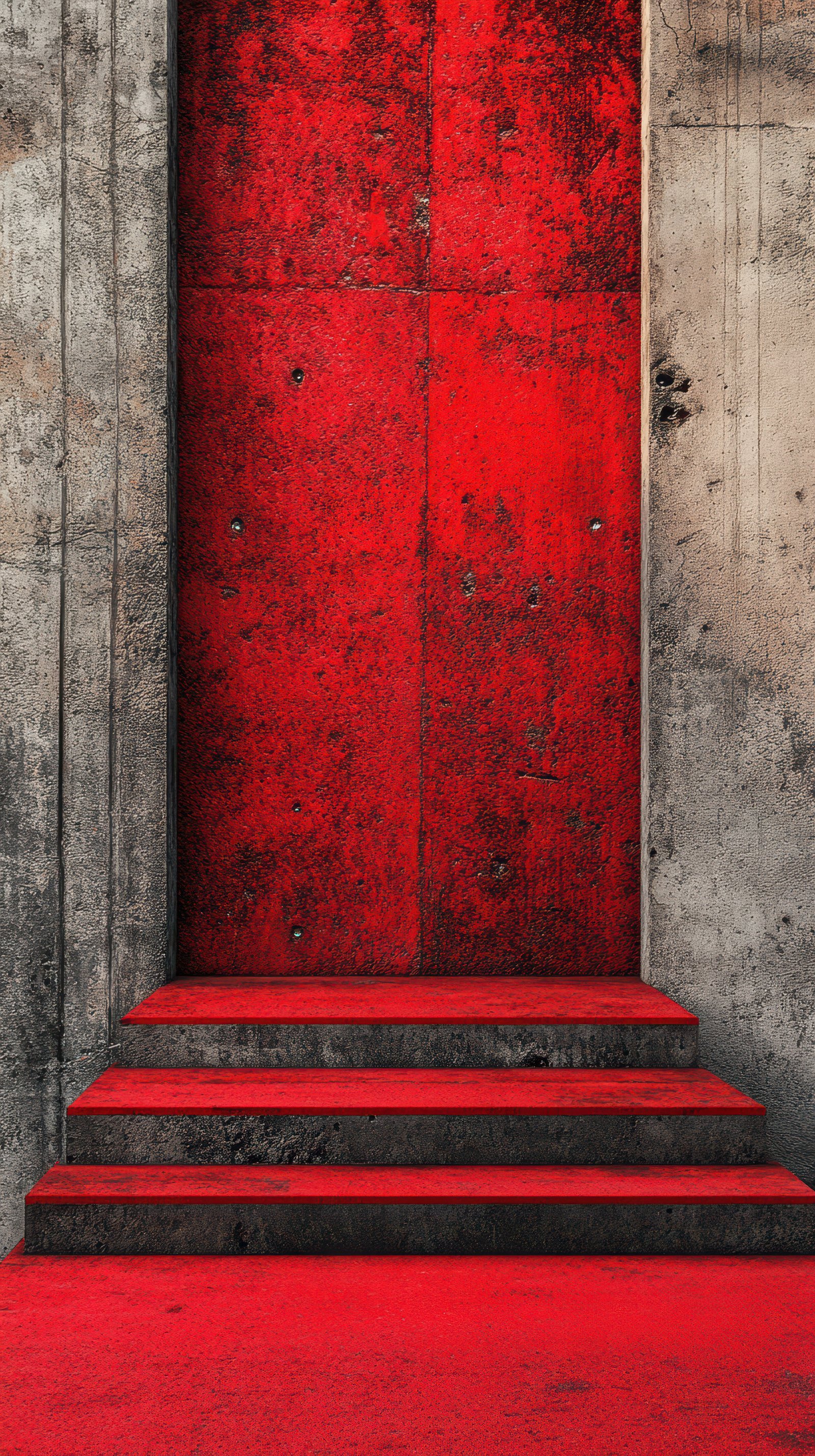 Vibrant red door against textured concrete wall with steps leading up in urban setting